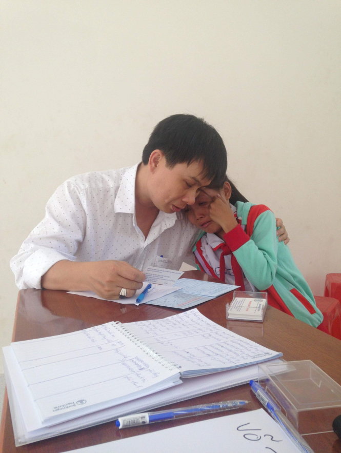 A girl that Le Minh Hien helped leans against him in this provided photo.