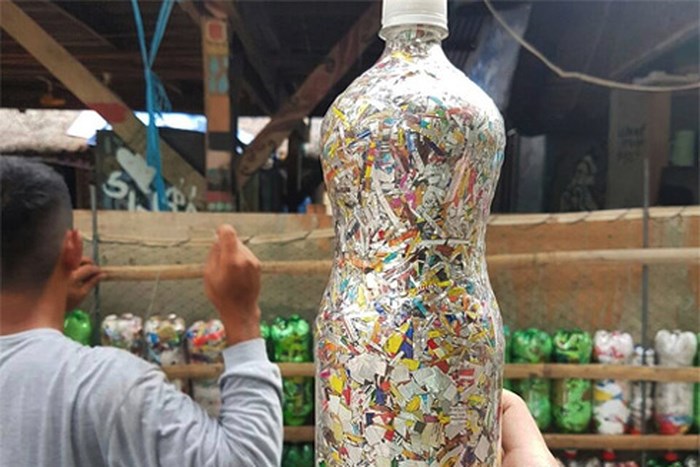 A close-up of an ecobrick made of unrecyclable waste pressed into a plastic water bottle. Photo: An Ninh Thu Do