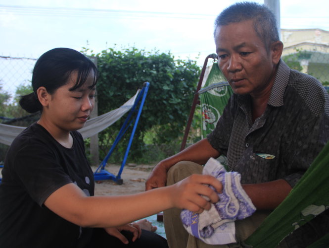 Truong Thi My Hieu takes care of her father at their house in Ninh Thuan Province, south-central Vietnam. Photo: Tuoi Tre
