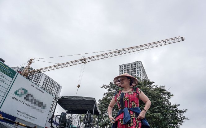 A construction crane operates above pedestrians and moving traffic in Hanoi without safety precautions. Photo: Tuoi Tre