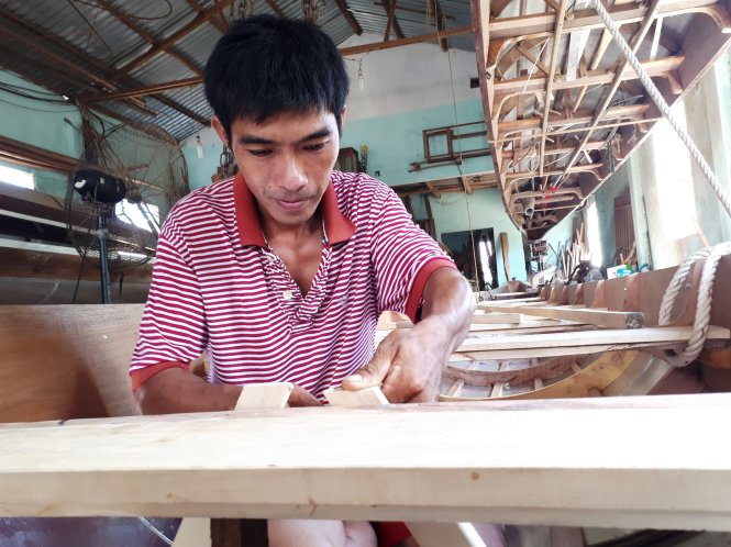 One of Pham Nhut’s sons, Pham Phu Phuoc, makes a boat at his workshop in Quang Nam Province, central Vietnam. Photo: Tuoi Tre