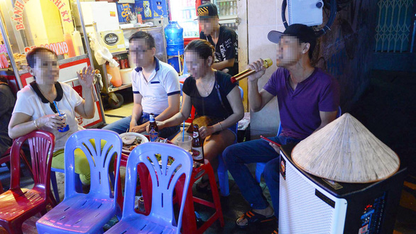 People sing karaoke along the sidewalk in Ho Chi Minh City. Photo: Tuoi Tre