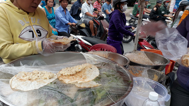 A seller wears plastic gloves while serving food at a stall in Ho Chi Minh City’s District 8. Photo: Tuoi Tre