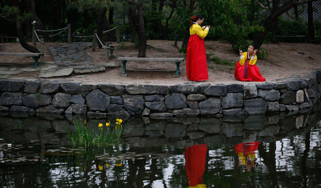 Women wearing traditional Korean Hanbok costume take a photo before a traditional coming-of-age day ceremony at Namsangol Hanok Village in Seoul May 20, 2013.