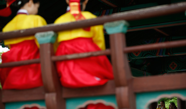 Women wearing traditional Korean Hanbok costume take photos before a traditional coming-of-age day ceremony at Namsangol Hanok Village in Seoul May 20, 2013.