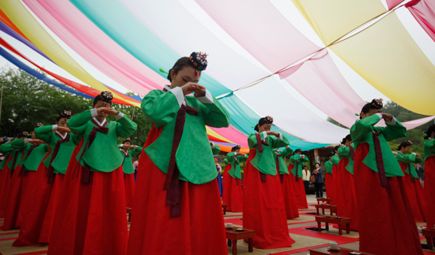 Women wearing traditional Korean Hanbok costumes perform deep bows during a traditional coming-of-age day ceremony at Namsangol Hanok Village in Seoul May 20, 2013.