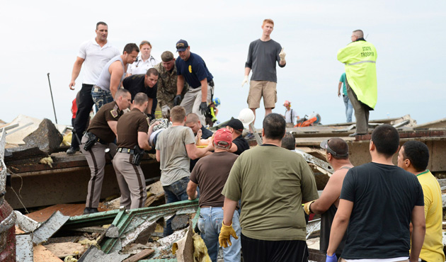 Rescue workers help free one of the 15 people that were trapped at a medical building at the Moore hospital complex after a tornado tore through the area of Moore, Oklahoma May 20, 2013.