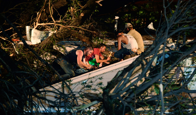 Residents help repair the roof of their neighbour's house which was damaged by a fallen tree when a tornado swept through Shawnee, in Oklahoma May 19, 2013.