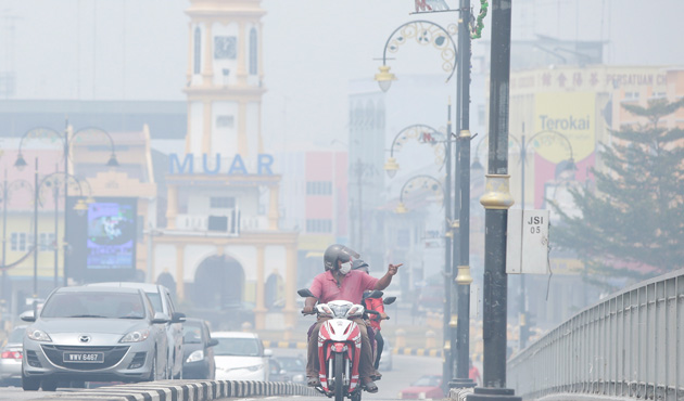 A motorist wears a face mask as he rides in the haze-covered town of Muar, in Malaysia's southern state of Johor June 23, 2013.