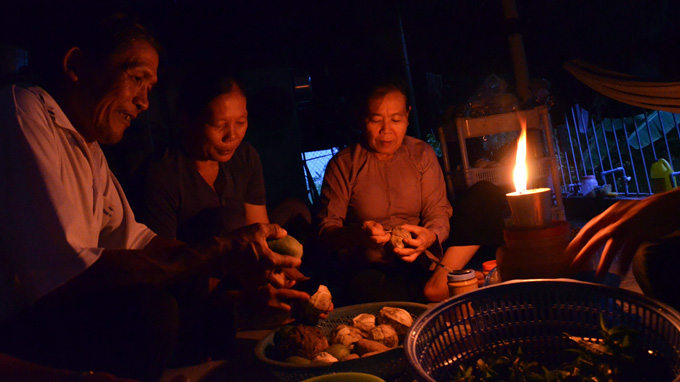 Le Minh Thanh helps two local women peel vegetables to serve to the poor.