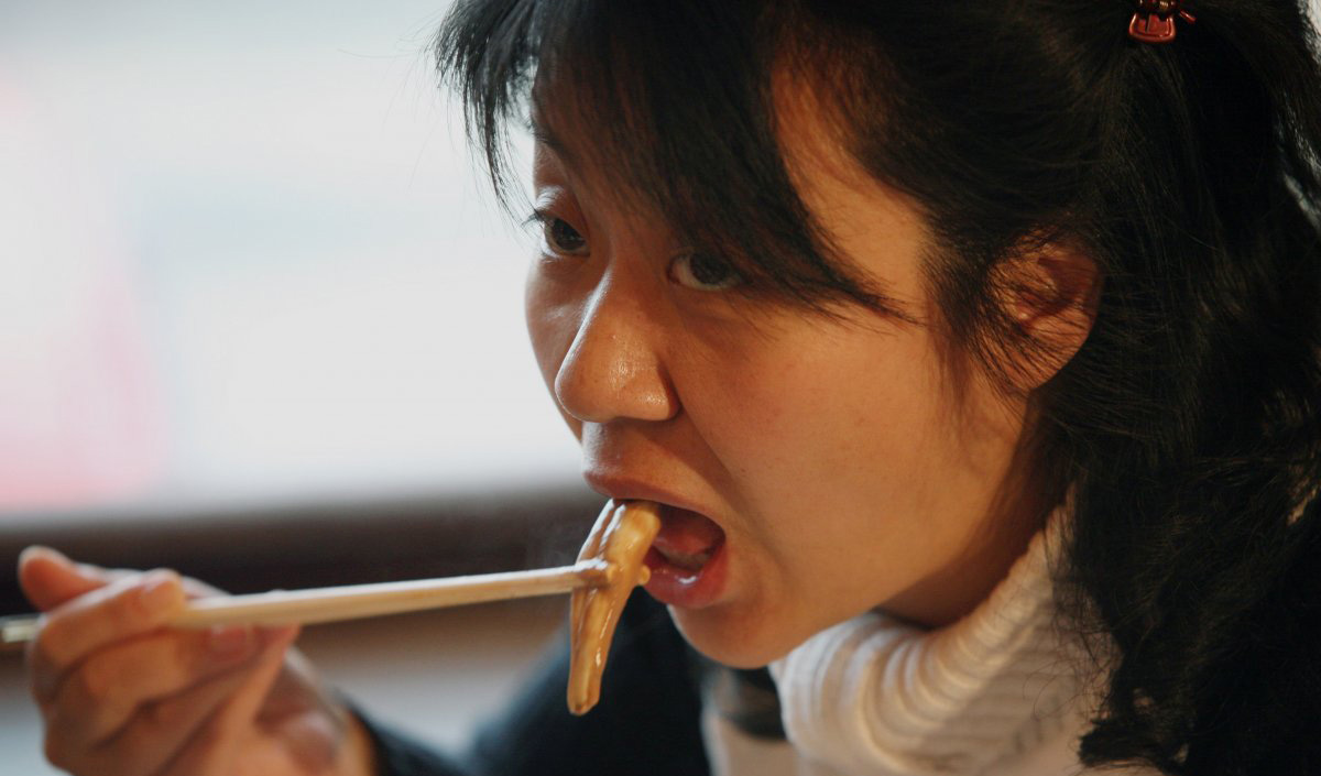 A Chinese woman eats from an ox and dog penis dish at a penis restaurant in Beijing that serves over 30 types of animal penises in traditional hotpot style. In China, many animal penises are thought to have medicinal properties.