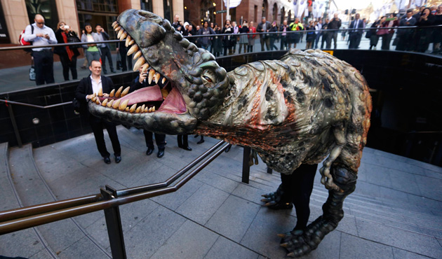A performer dressed in a Tyrannosaurus rex dinosaur costume walks amongst pedestrians during a publicity event in central Sydney August 28, 2013.