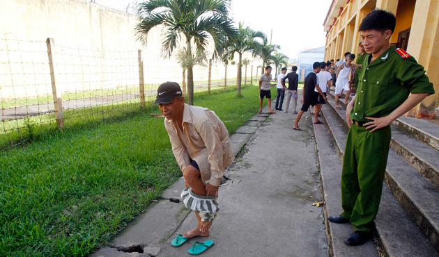 A man takes off his prison uniform while he is being released from Hoang Tien prison, about 100 km (62 miles) outside Hanoi August 30, 2013.