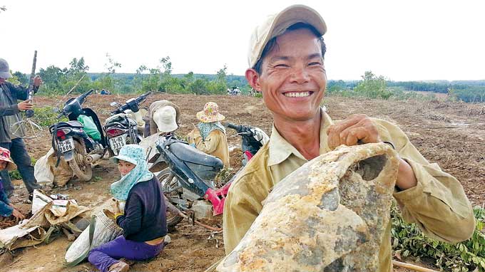 Tran Van Ngac from Tan Hiep village looks happy with a 35kg metal piece in his hands.