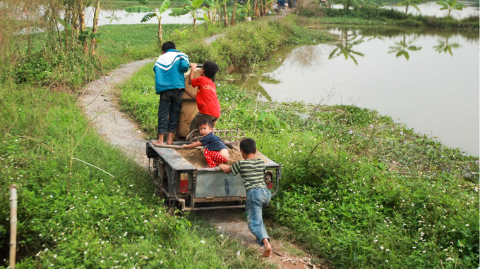 The kids carry water and some building materials on a three-wheeled vehicle that the couple borrows from a neighbor.