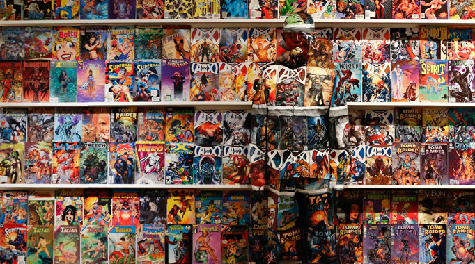 Liu Bolin, a Chinese artist, blends himself into the background in front of a shelf lined with comic books as part of a series of performances in Caracas, November 2, 2013.