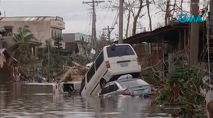 Vehicles are pictured stranded in a flooded street filled with debris after Typhoon Haiyan hit the central Philippine city of Tacloban, Leyte province in this still image from video November 8, 2013.