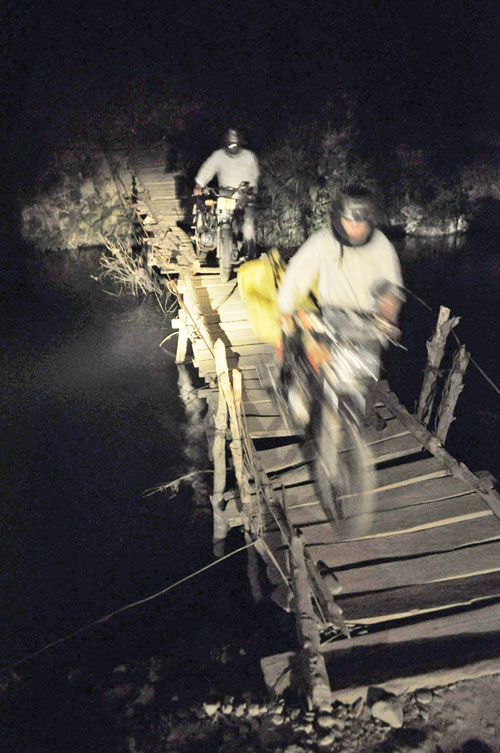 Two motorists have to grope their way in the dark to cross an improvised suspension bridge in Phuc Than commune of Lai Chau’s Than Yen District.