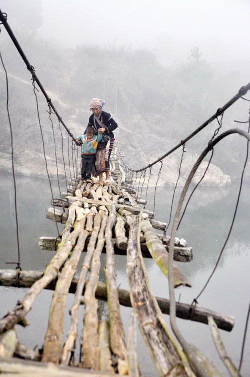 Every day Lo Thi Son, a native woman in Khon Doi hamlet, gets up very early to bring her two-year-old son to school. To take him there safely, she has to cross a ratty suspension bridge first.