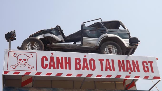 Vietnam businessman turns car wreckage into traffic danger sign