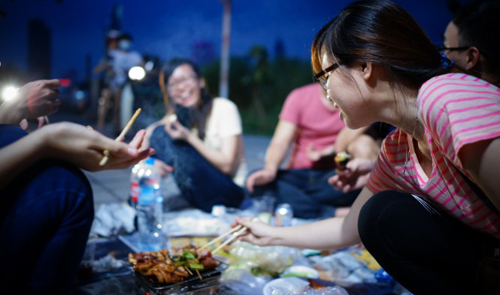 Picnic-goers are seen preparing a barbecue on the sidewalk of Mai Chi Tho Boulevard in District 2, Ho Chi Minh City.