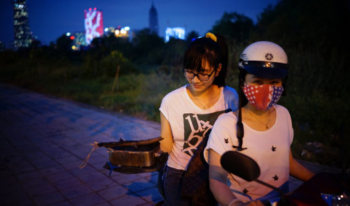 Two students of the University of Economics-Ho Chi Minh City bring a cooker to prepare for their night picnic on Mai Chi Tho Boulevard in District 2, Ho Chi Minh City.