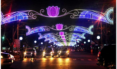 A Ho Chi Minh City street sparkles at night with colorful lights.