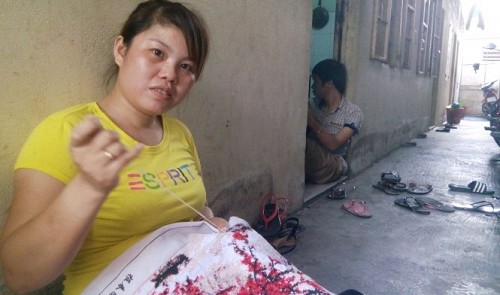 29-year-old worker Cao Thi Thuy spends almost a year creating her embroidery painting, which she hopes will earn her some extra money for Tet spending.