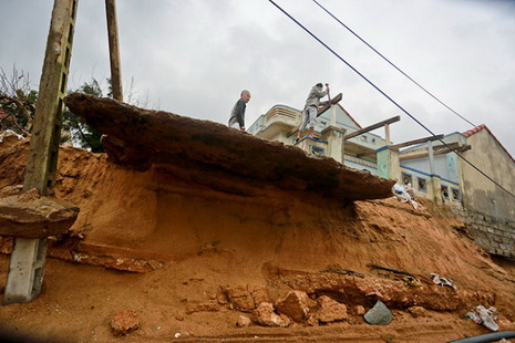 Rough sea waves intrude on the foundations of houses along Dinh Tien Hoang Street.