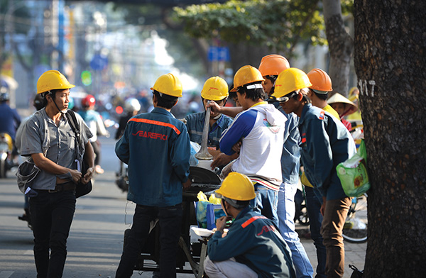 A group of workers have breakfast under the early morning sunlight in Ho Chi Minh City.