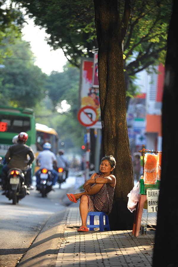 A banh trang (rice paper) street seller waits for customers in the last light of the day.