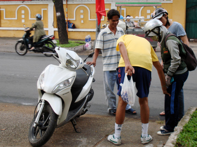 A common sight in HCMC streets unfolds as a young woman’s bike fell over on Nam Ky Khoi Nghia street during rush hour, at 7.50 on January 5, 2015. Her bike was immediately taken to the sidewalk and she was surrounded by some caring passengers.