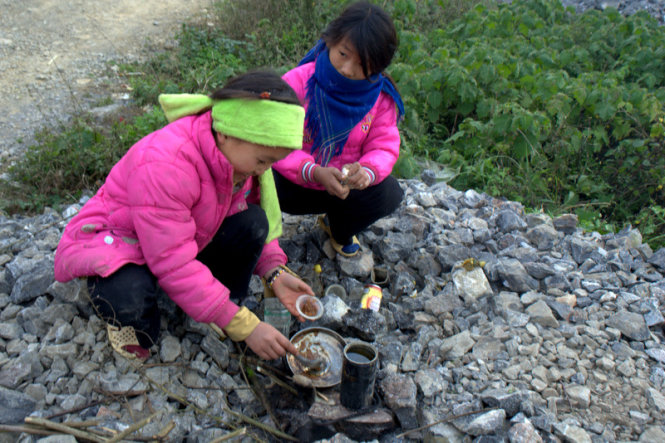 Two girls are seen playing a cooking game on the way to Xin Cai Commune.
