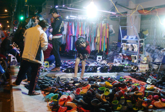 Past 12:00 am on February 11, 2015, the footwear and clothing stalls on District 1’s Nguyen Trai Street were still packed with young clients.