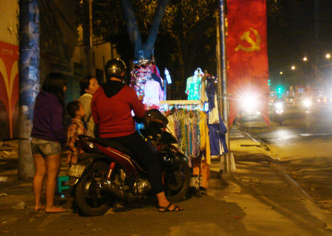 A young couple is pictured picking Tet clothes for their would-be little son at an isolated stall on Binh Thanh District’s Phan Dang Luu Street at 11:16 pm on February 11, 2015.