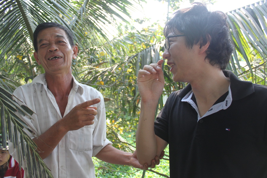Yasuhiro Asahi (R), a Japanese student, tried to communicate with a local in Vietnam’s southern province of Long An using Vietnamese, English as well as his body language.
