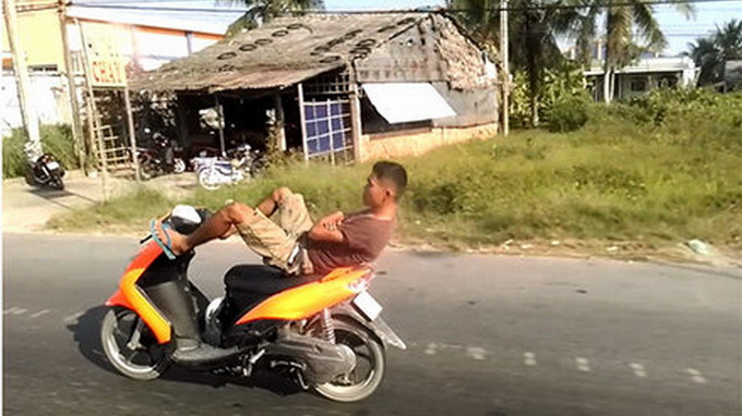 Watch this man drive scooter with his legs on Vietnam highway