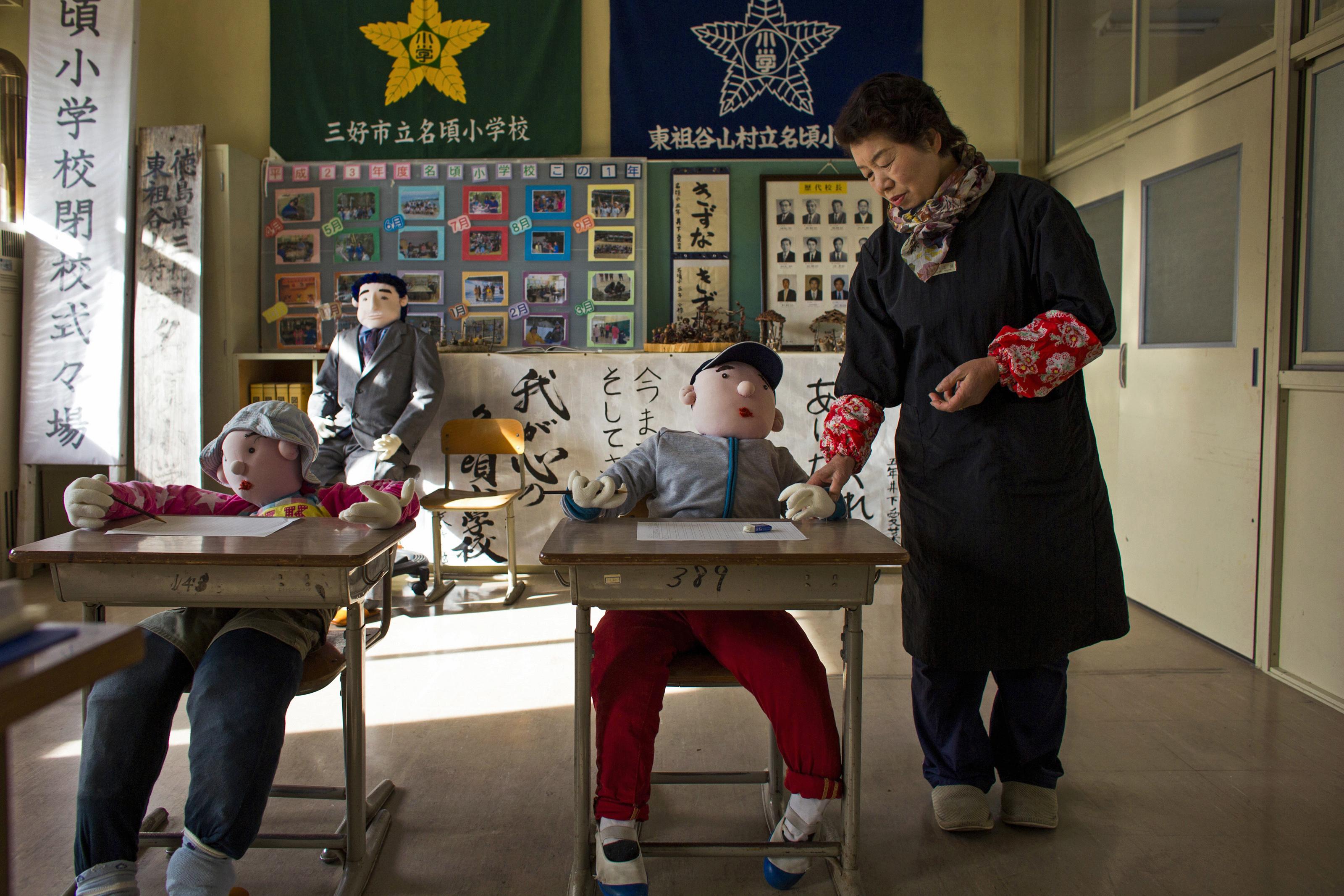 Tsukimi Ayano stands in a classroom with scarecrows at a closed down school in the village of Nagoro on Shikoku Island in southern Japan February 24, 2015.