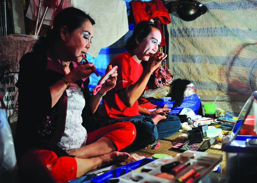 Artists carefully make up before going to the stage.