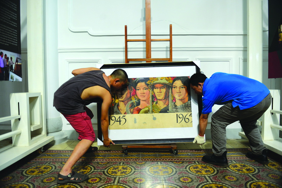 Two people install a picture for an exhibition at the Ho Chi Minh City Fine Art Museum in District 1.