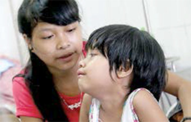 Ethnic Vietnamese teen mothers young sister during blood cancer battle