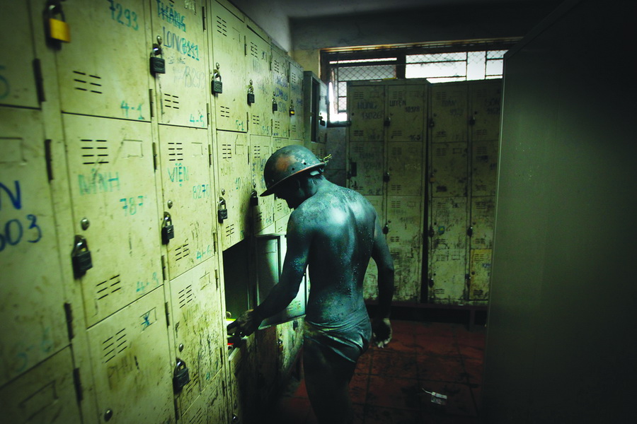 A coal miner collects his personal belongings in a locker room after his shift.