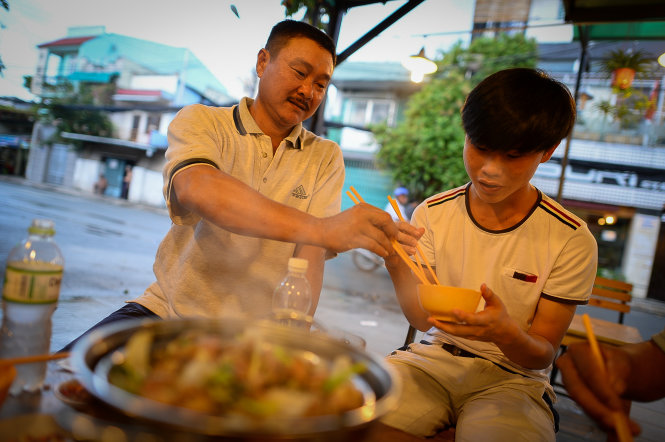 Ly Thanh Huy from Binh Phuoc Province treats his son to a good dinner one day before the exam at a goat meat eatery on Le Loi Street in Go Vap District, Ho Chi Minh City.
