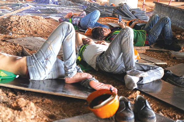 Workers are pictured taking a nap at a construction site.