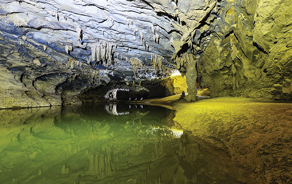 A big river with a yellow sandbank in Kim Cave.