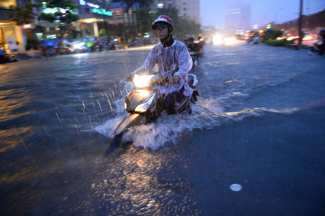A driver tries to get through a heavily flooded section of  Nguyen Huu Canh Street.