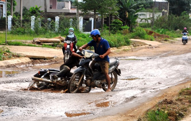 In Vietnam, residents struggle to drive on dusty roads full of potholes