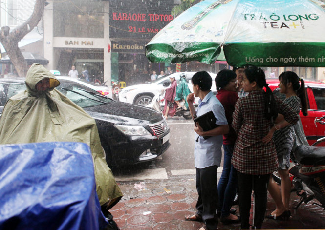 Diners patiently wait in front of the outlet despite the heavy rain.