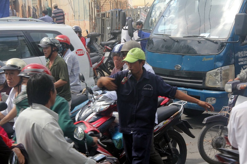 A garbage collector attempts to control the flow of traffic, preventing people from traveling on the wrong lanes.