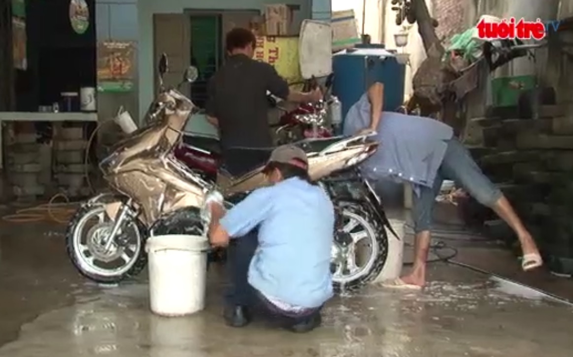 Motorbike wash-stop with hearing impaired workers in southern Vietnam